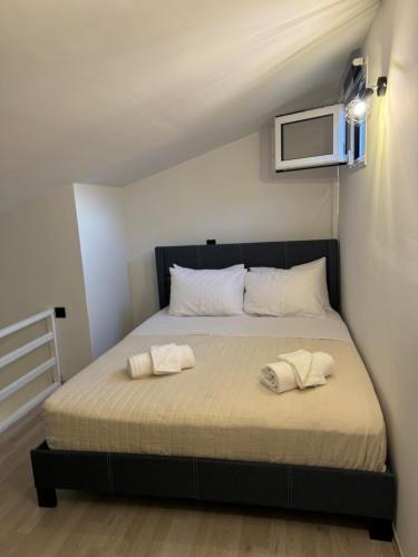 a bedroom with a bed with two towels on it at SmallHouseLefkada ΘΕΜΑ in Lefkada Town