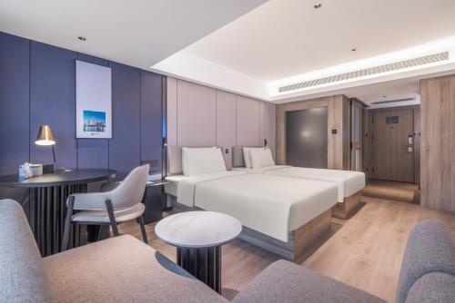 Una habitación de hotel con una cama grande y sillas. en Atour Hotel Guangzhou Tianhe Sports Center - Free Shuttle bus to Canton Fair Hall & Free self-service laundry & Free midnight snack & near canton fair Purchaser certificate office & big shopping mall, en Guangzhou