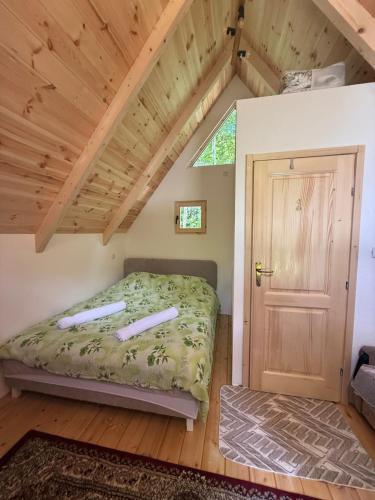 a small bedroom with a bed and a door at WildBeauty Grebaje in Vusanje