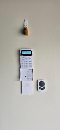 a fax machine sitting on a wall with a clock at Stylish 3 bedroom home in Palmerston North in Palmerston North