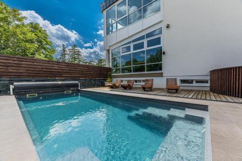 a swimming pool in front of a house at Hotel Lesana in Vysoké Tatry