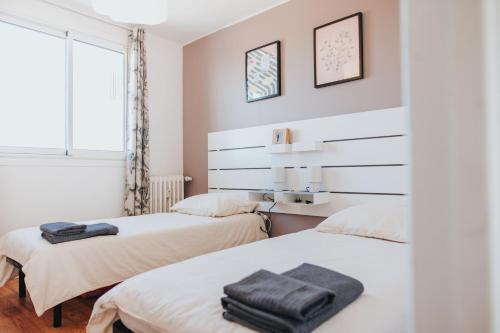 deux lits dans une chambre aux murs blancs dans l'établissement BonAltitude - T3Bis - Sérénité, vue sur Pyrénées, à Toulouse