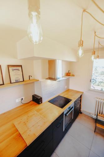 une cuisine avec un comptoir en bois et un comptoir dans l'établissement BonAltitude - T3Bis - Sérénité, vue sur Pyrénées, à Toulouse