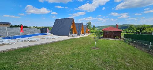 a building with a yard with a small tree at Wild A-frame in Baile Felix