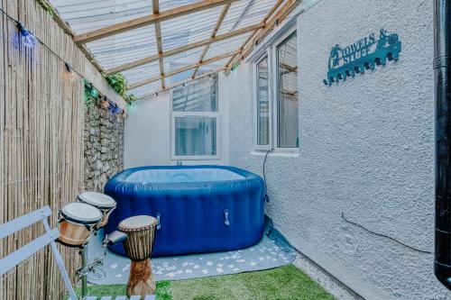 a large blue tub sitting next to a building at Open Mind Property - 4 Bedroom House with Hot Tub in Weston-super-Mare