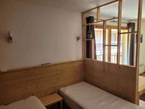 une chambre avec un banc et une fenêtre. dans l'établissement Hameau des Eaux d'Orelle 3 Vallées - 2 Studios Communicants, à Orelle