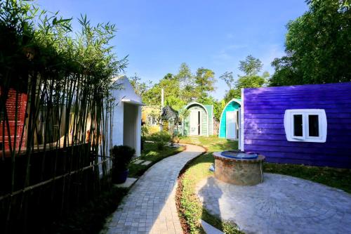 une maison violette avec une clôture à côté d'un trottoir dans l'établissement Minh Hầu Lạc Trú Homestay, à Ấp Long Hồ Hạ
