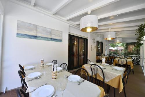a dining room with white tables and chairs at Hotel Fiorita in Bellaria-Igea Marina
