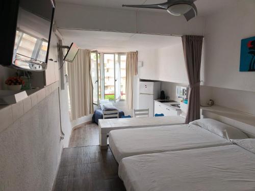 une chambre d'hôtel avec deux lits et une cuisine dans l'établissement Alma de Mar, à La Pineda