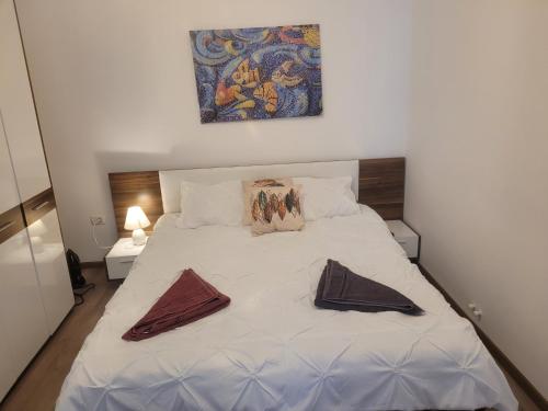 a bedroom with a white bed with two pillows on it at Apartament GabRox in Mamaia Sat/Năvodari
