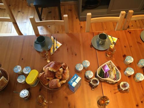 een houten tafel met daarop brood en bekers bij La compagnie du bourg in Le Châtelard