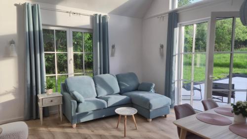 a living room with a couch and a table at Káli Pillangó - Ház a völgyben in Balatonhenye