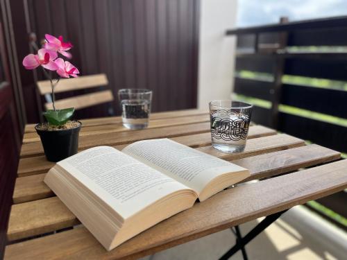 an open book on a wooden table with two glasses at Ferienwohnung in Freudenstadt-Kniebis III in Freudenstadt