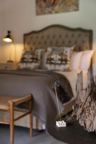 a bedroom with a bed and a table with a table sidx sidx sidx at Sashwa River of Stars Plant-Based Wellness Safari Lodge in Hoedspruit