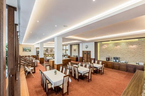 a restaurant with tables and chairs and a brick wall at Hotel Lesana in Vysoké Tatry