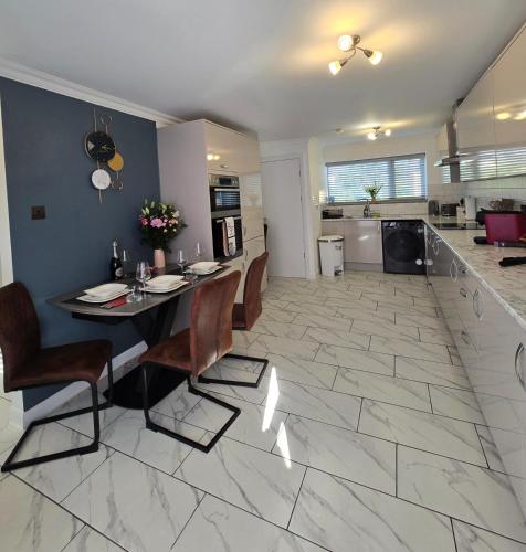 a kitchen and living room with a table and chairs at Luxury Modern Comfy 3BR House Contractors Family in Kettering