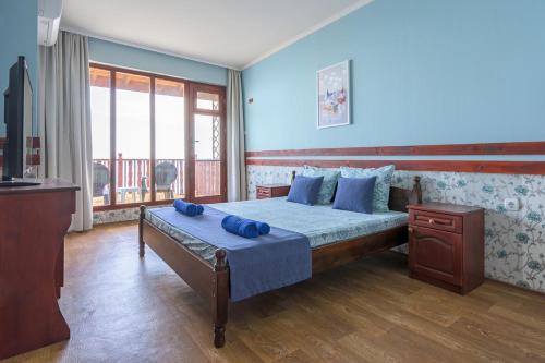 a bedroom with a bed with blue pillows on it at Morski Briag Hotel in Golden Sands
