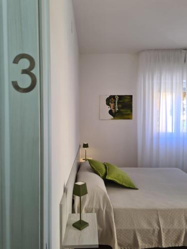 a white bedroom with a bed and a window at B&B testa di Moro in Giarre