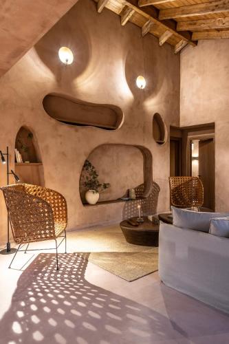 a living room with chairs and a couch and a table at Terracotta Fiscardo Villas in Fiskardho