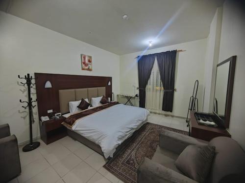 a bedroom with a large bed and a couch at Al Eairy Apartments - Al Ahsa -2 in Al Ahsa