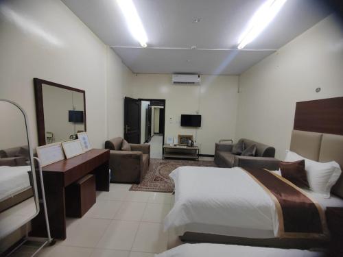 a hotel room with a bed and a living room at Al Eairy Apartments - Al Ahsa -2 in Al Ahsa