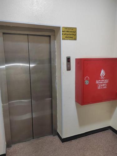 a metal elevator door with a sign on the wall at Al Eairy Apartments - Al Ahsa -2 in Al Ahsa