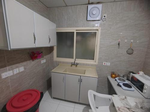 a small kitchen with a sink and a microwave at Al Eairy Apartments - Al Ahsa -2 in Al Ahsa