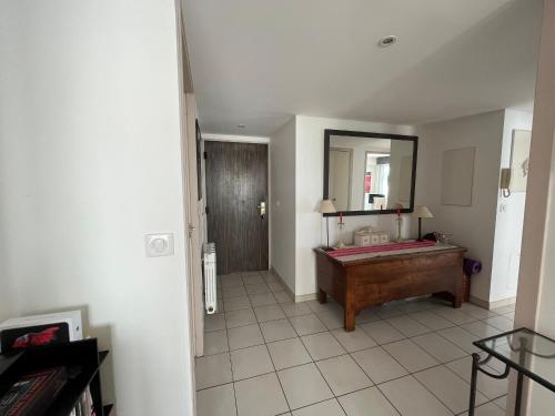 La salle de bains est pourvue d'un grand miroir et d'une baignoire. dans l'établissement Appartement T3 Central à Arcachon avec Vue Mer, Terrasse, Wifi et Parking - FR-1-374-52, à Arcachon