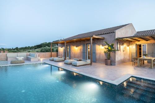 a swimming pool in front of a house at Terracotta Fiscardo Villas in Fiskardho