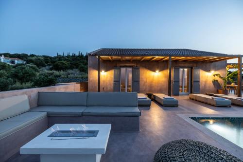 a living room with a couch and a pool at Terracotta Fiscardo Villas in Fiskardho