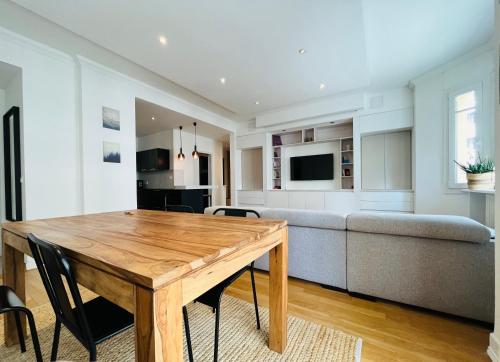 un salon avec une table en bois et un canapé dans l'établissement Îlot lac Central et moderne, à Annecy