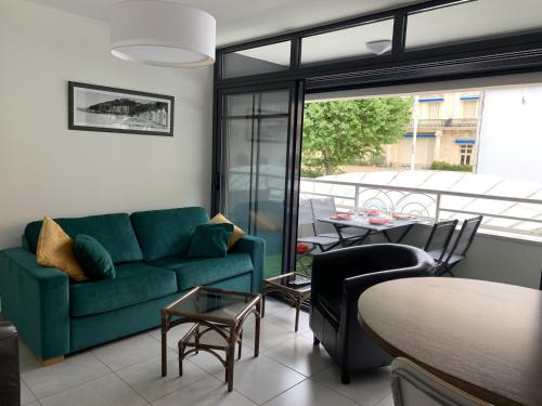 un salon avec un canapé vert et une table dans l'établissement Charmant T3 au cœur d'Arcachon, à 50m de la plage & 300m de la gare, parking et WiFi inclus - FR-1-374-121, à Arcachon