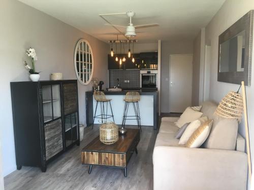 un salon avec un canapé et une table dans l'établissement Appartement rénové centre Moulleau avec balcon et parking - FR-1-374-159, à Arcachon