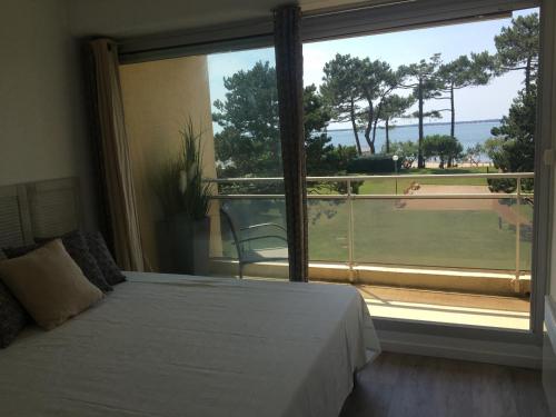 une chambre avec un lit et une grande fenêtre dans l'établissement Appartement rénové centre Moulleau avec balcon et parking - FR-1-374-159, à Arcachon