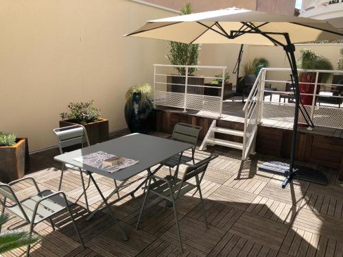 - une table et des chaises avec un parasol dans la chambre dans l'établissement Superbe T2 avec Wifi, terrasse 100m², parking au centre d'Arcachon - FR-1-374-207, à Arcachon