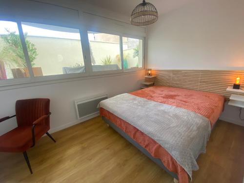 une chambre avec un lit, une chaise et une fenêtre dans l'établissement Superbe T2 avec Wifi, terrasse 100m², parking au centre d'Arcachon - FR-1-374-207, à Arcachon