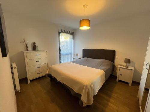 une chambre avec un lit, une commode et une fenêtre dans l'établissement Charmant T3 à Arcachon avec terrasse et parking sécurisé - FR-1-374-233, à Arcachon