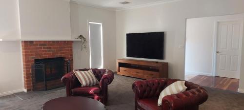 a living room with two chairs and a television at Luxurious stay with amazing views in Bacchus Marsh