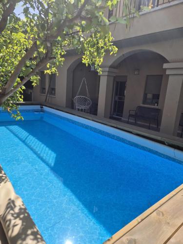 a swimming pool with blue water in front of a building at Anecdote in Ramat Yishay