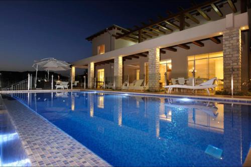 a swimming pool in front of a house at night at אחוזת הכורמים חד נס - סוויטות עם Hot-tub פרטי in Had Nes