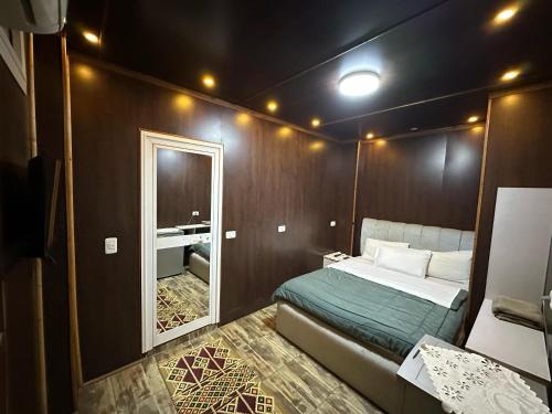 a small bedroom with a bed and a mirror at Cheers Hostel Cairo in Cairo