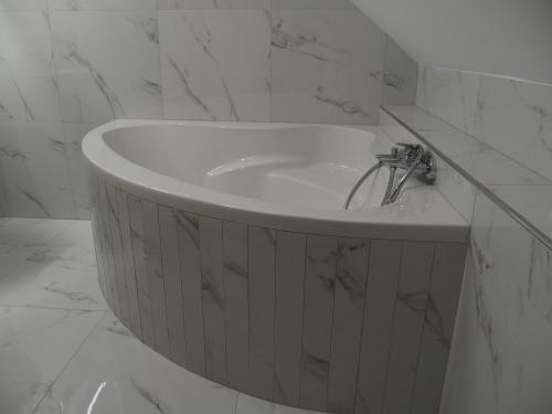 a white sink in a bathroom with marble walls at Sjezdovka Bušín in Busin