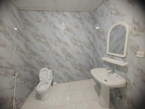 a bathroom with a sink and a toilet and a mirror at Al Eairy Apartment-Alqaseem 4 in Buraydah