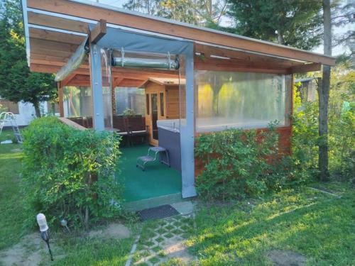 a small house with a green floor and a window at Holiday home with Jakuzzi and Sauna in Kisoroszi