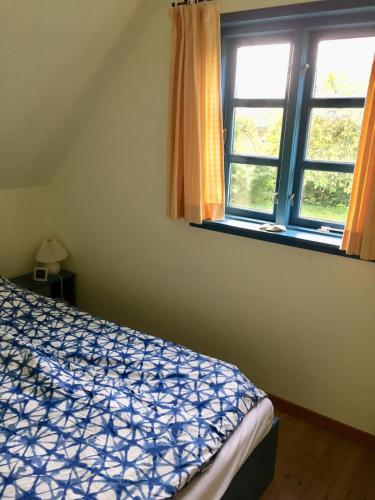 a bedroom with a bed and a window at Bauernhaus mit großem Garten in Jordløse
