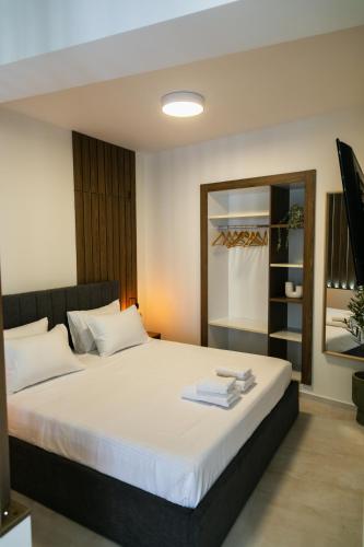 a bedroom with a large white bed with a mirror at Casa Margarita Parga in Parga