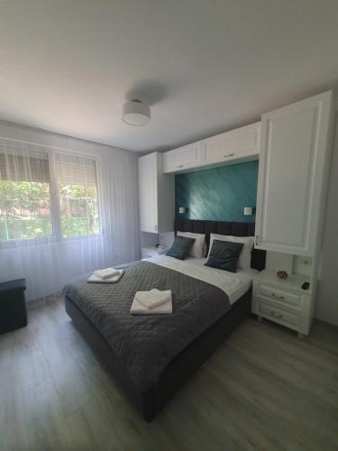a bedroom with a large bed with two towels on it at Apartament Zeuss Neptun in Neptun