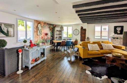 - un salon avec un canapé jaune et une cheminée dans l'établissement Parenthèse basque, piscine chauffée, proche océan, à Mouguerre