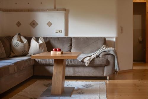 a living room with a couch and a wooden table at Landhaus Trinker in Schladming