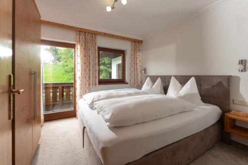 a bedroom with a large bed and a window at Landhaus Trinker in Schladming